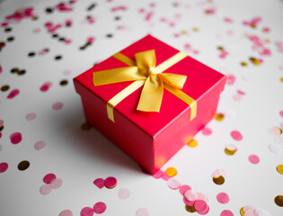 gift box with bow on a light background with confetti