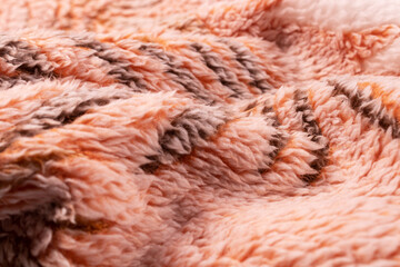 evenly folded blanket with a black pattern in orange with a white cover