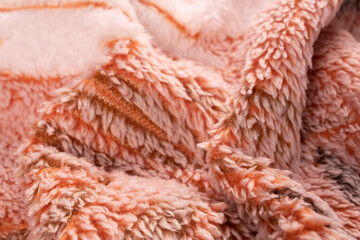 orange blanket with a white blanket folded in a pile