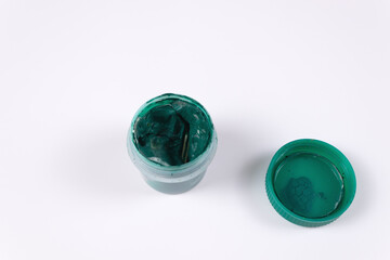 Green jar of gouache open and next to the lid from it top view