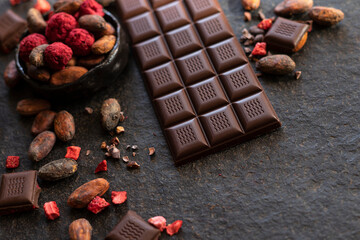 Dark chocolate pieces crushed and cocoa beans, culinary background, top view