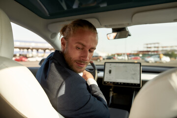 Young businessman on driver seat looking backwards