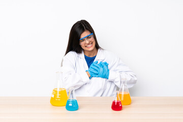 Young scientific woman in a table having a pain in the heart