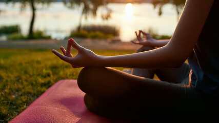 Relaxation exercises. Cropped shot of a woman practicing yoga in the morning outdoors, sitting in...