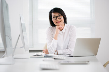 Asian business woman smiling at camera in an office