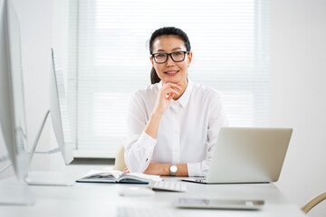 Asian business woman smiling at camera in an office