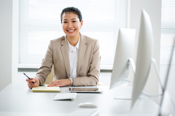 Asian business woman smiling at camera in an office