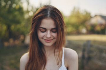 Naklejka premium portrait of a beautiful woman in a white sundress outdoors in the garden