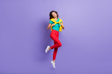 Fototapeta na wymiar Full length body size view of lovely cheerful wavy-haired girl jumping having fun isolated over violet pastel color background