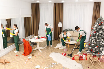 Cleaning service team working in messy room after New Year party