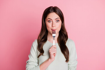 Portrait of adorable curly hairstyle lady biting lick fork smile isolated on pastel pink color background