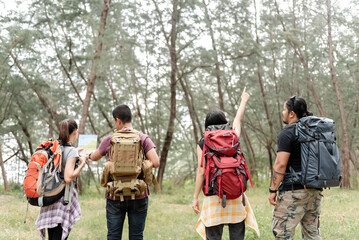Adventure Hikers Navigating Forest Path with Map and Directional Guidance for Ecotourism Concept