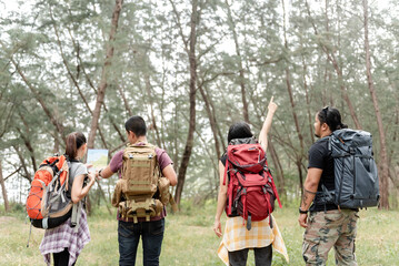 Concept adventure and hiking, male and female back-packers Asians group are four people went into the woods to explore.