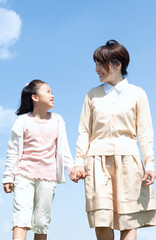 Fototapeta premium 手をつないで歩く母親と娘
