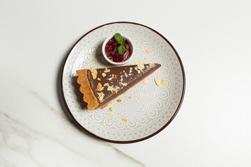 Chocolate cake pie served with raspberry jam in the plate