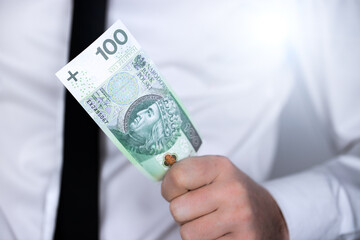 Polska waluta, sto złotych, 100 PLN. Banknot trzymany w ręce - obrazy, fototapety, plakaty
