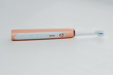 pink electric toothbrush for adults, over white background. Daily oral care.