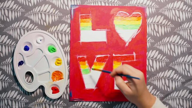 The process of hand drawn creating. Top view. Creative and professional development of LGBT artists. Queer aesthetics is modern and contemporary visual art practices. Acrylic rainbow colors. 