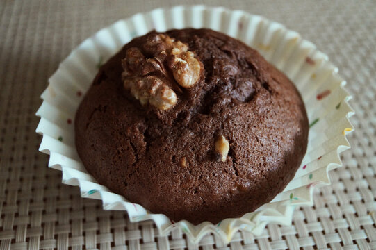 baking chocolate cupcake with walnut on the table horizontal macro photo