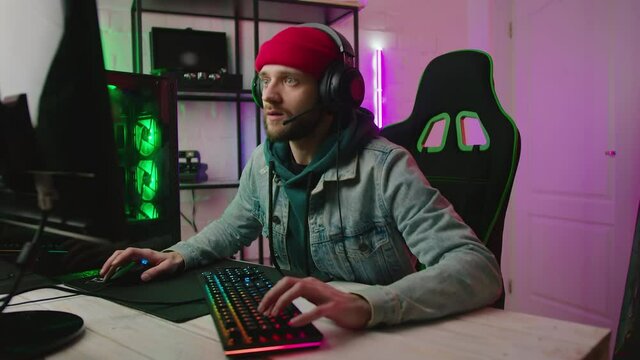 Gamer playing online video game in pc at home. Colorful Neon Led Lights. Play Cyber Gaming Tournament and Have live stream.