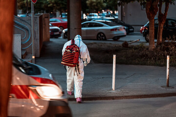 Obraz premium Tired medical worker going home after long day fighting corona virus covid-19. Health worker wearing personal protective equipment arrive to help during the COVID-19 Coronavirus pandemic.