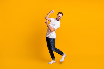 Fototapeta na wymiar Full size profile photo of optimistic guy dance sing wear grey t-shirt jeans sneakers isolated on yellow color background