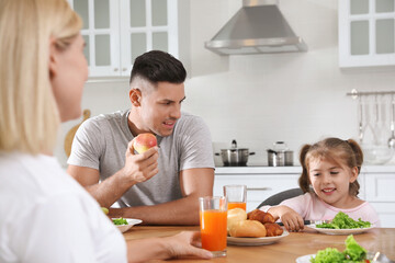 Obraz na płótnie Canvas Happy family having breakfast together at table in modern kitchen