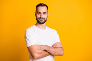 Fototapeta premium Portrait of attractive cheerful sportive masculine guy folded arms isolated over bright yellow color background