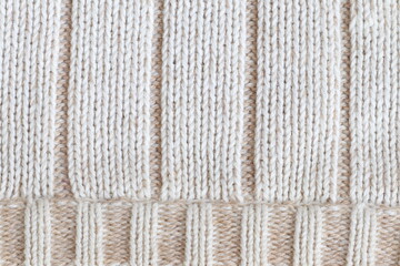 The texture of a light knitted sweater fabric.