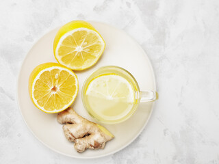 Top view cup of ginger and lemon lemonade with ingredients in plate