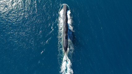 Aerial drone photo of latest technology armed diesel powered submarine cruising half submerged deep...