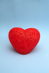 Red acrylic heart on blue background with place for text