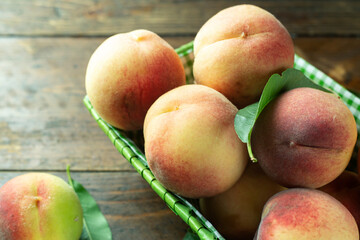 Ripe peaches in basket on wooden background. Home harvest from your own garden.