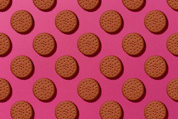 Sweet chocolate cookies flat lay pattern on light pink background.
