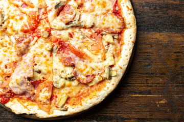 Fresh italian pizza with bacon, tomatoes, mushrooms and cheese on a wooden background.  Italian food. Space for text.
