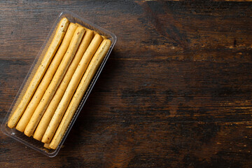 Homemade Italian Grissini Breadsticks on a wood background. Space for text.