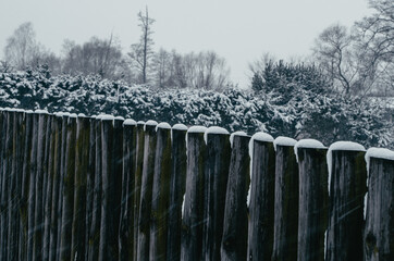 Wooden fence covered with snow on a winter day