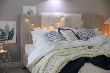 Cozy bedroom interior with warm blanket and cushions