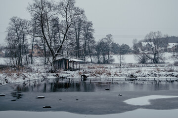 Wooden hut by frozen lake, horizontal view