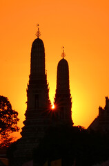 Setting Sun Shining Through the Silhouette of Wat Arun Temple 's Two of Four Smaller Spires,...