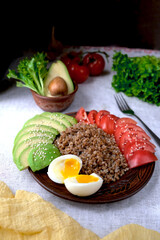 Diet and healthy menu. Buckwheat, tomatoes, avocado and an egg on a beautiful plate. Vegan food. Banner. View from above. 