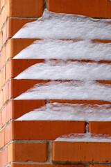 Fragment of a chimney covered with snow close up