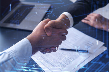 Handshake of two businessmen who enters into the contract to develop a new software to improve business service at a company. Technological icons over the table with the document.