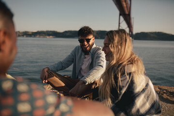 group of young adult friends hanging out at river together having fun