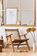Modern composition of living room interior with design armchair, wooden stool, old window, dried flowers in vase, brown mock up poster frame, decoration and elegant personal accessories. Template.