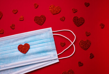Medical masks with red hearts on the red background. Coronavirus Valentines. Valentines day concept...