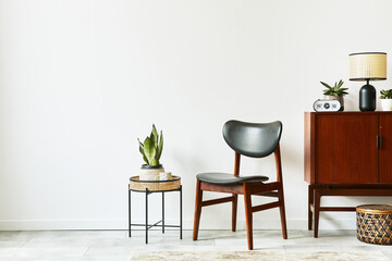 Stylish interior design of living room with wooden retro commode, chair,  plants, rattan basket, decoration, lamp, clock and elegant personal accessories. Copy space white wall. Template.