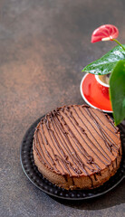 Classic chocolate cheesecake and a cup of coffee on a dark background. Homemade baking.
