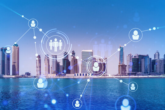 Skyscrapers of Dubai business downtown. International hub of trading and financial services. Social network icons hologram, concept of people connection. Double exposure. Dubai Canal waterfront.