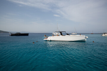 Fototapeta na wymiar Luxury small yacht anchoring in shallow water in greece